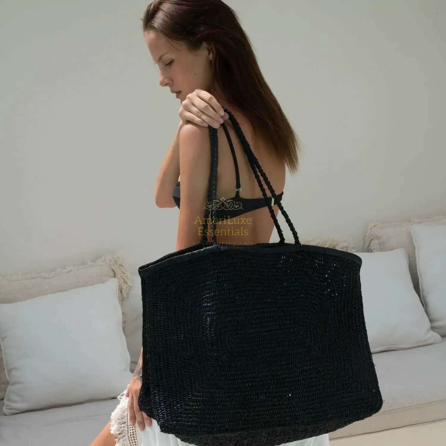 Model carrying a Clipa XXL raffia beach tote, showing its stylish design and ample size for beach outings.