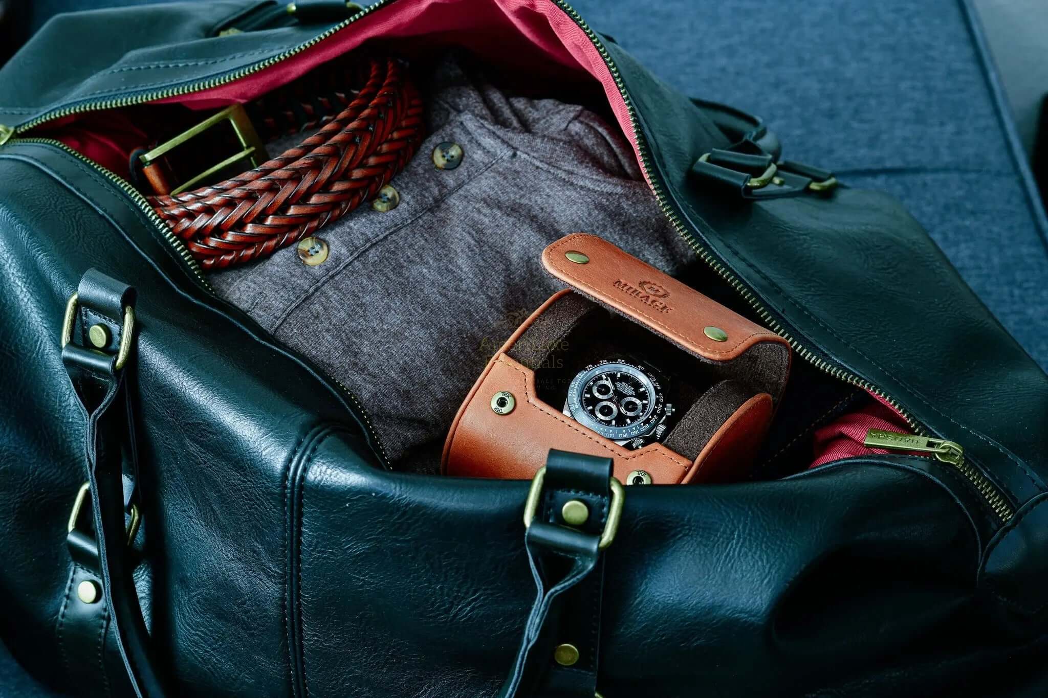 Tawny brown leather watch travel case inside a stylish black bag with a red lining, showcasing the luxury watch case.