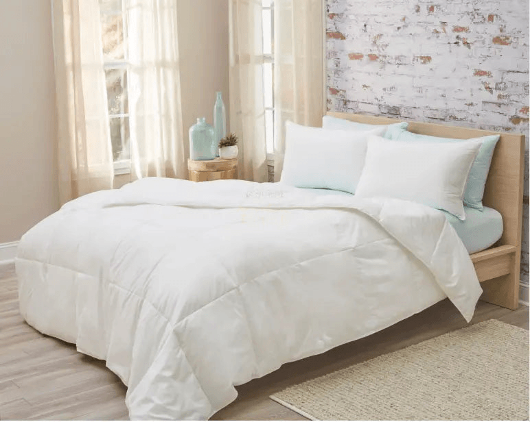 Lightweight goose down comforter on a bed with soft pillows in a cozy bedroom setting.