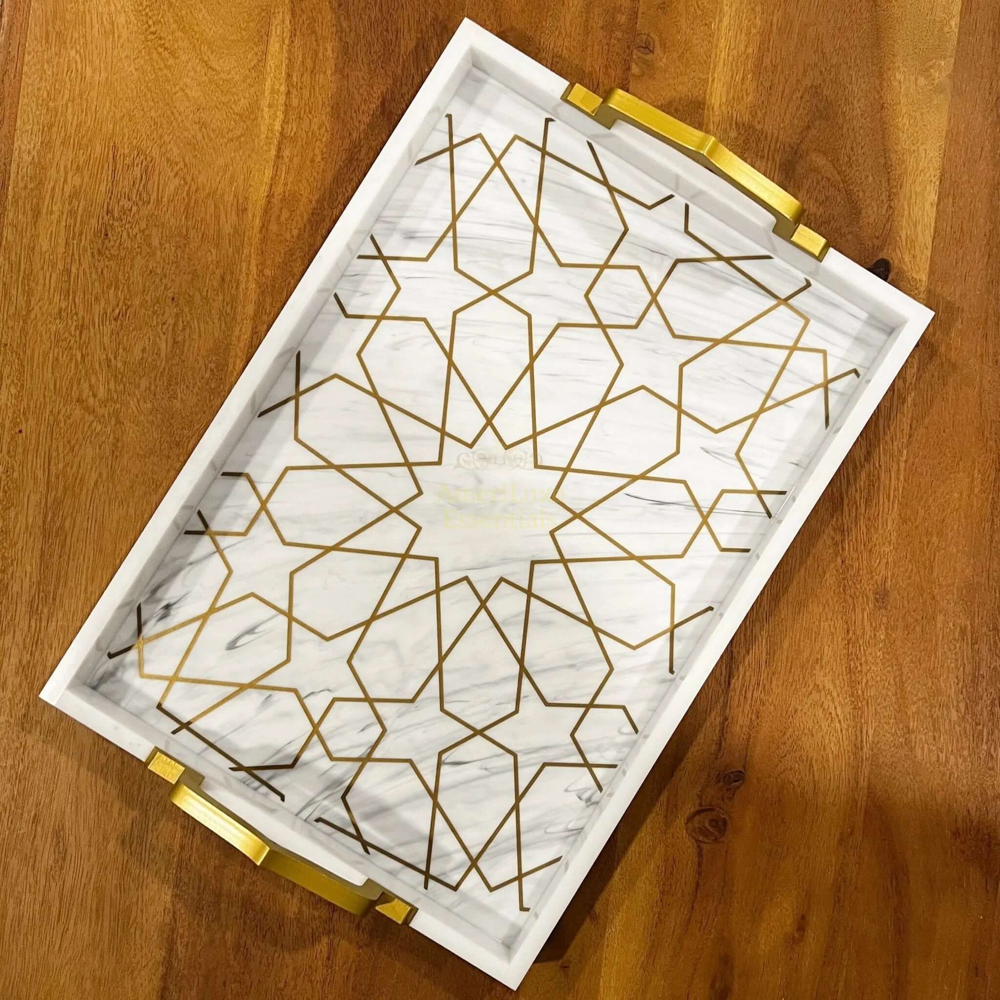 Elegant acrylic serving tray with gold geometric design and arched handles, perfect for serving or decoration.