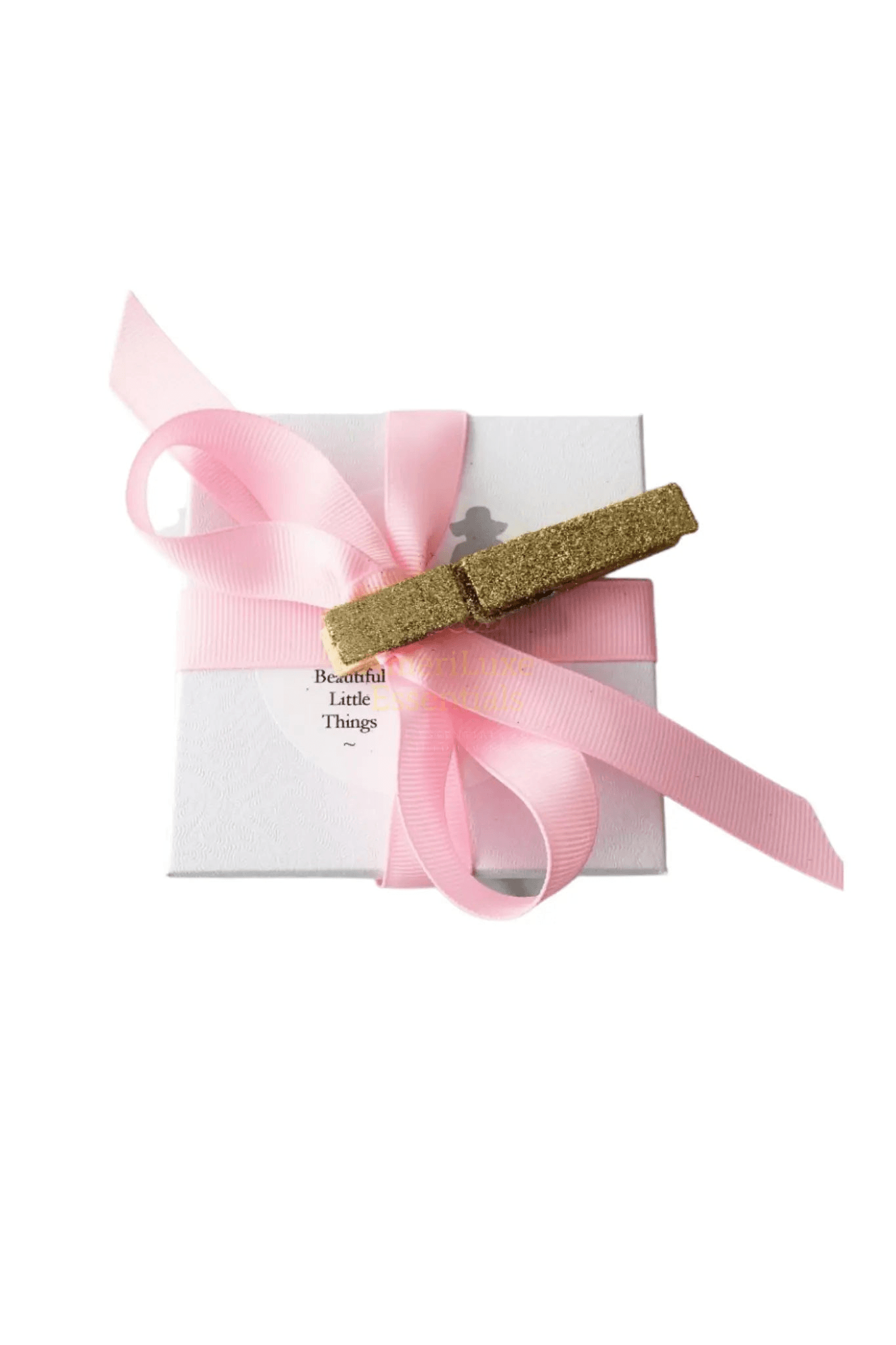 Gift box with pink ribbon and gold embellishment, perfect for presenting beautiful little things.