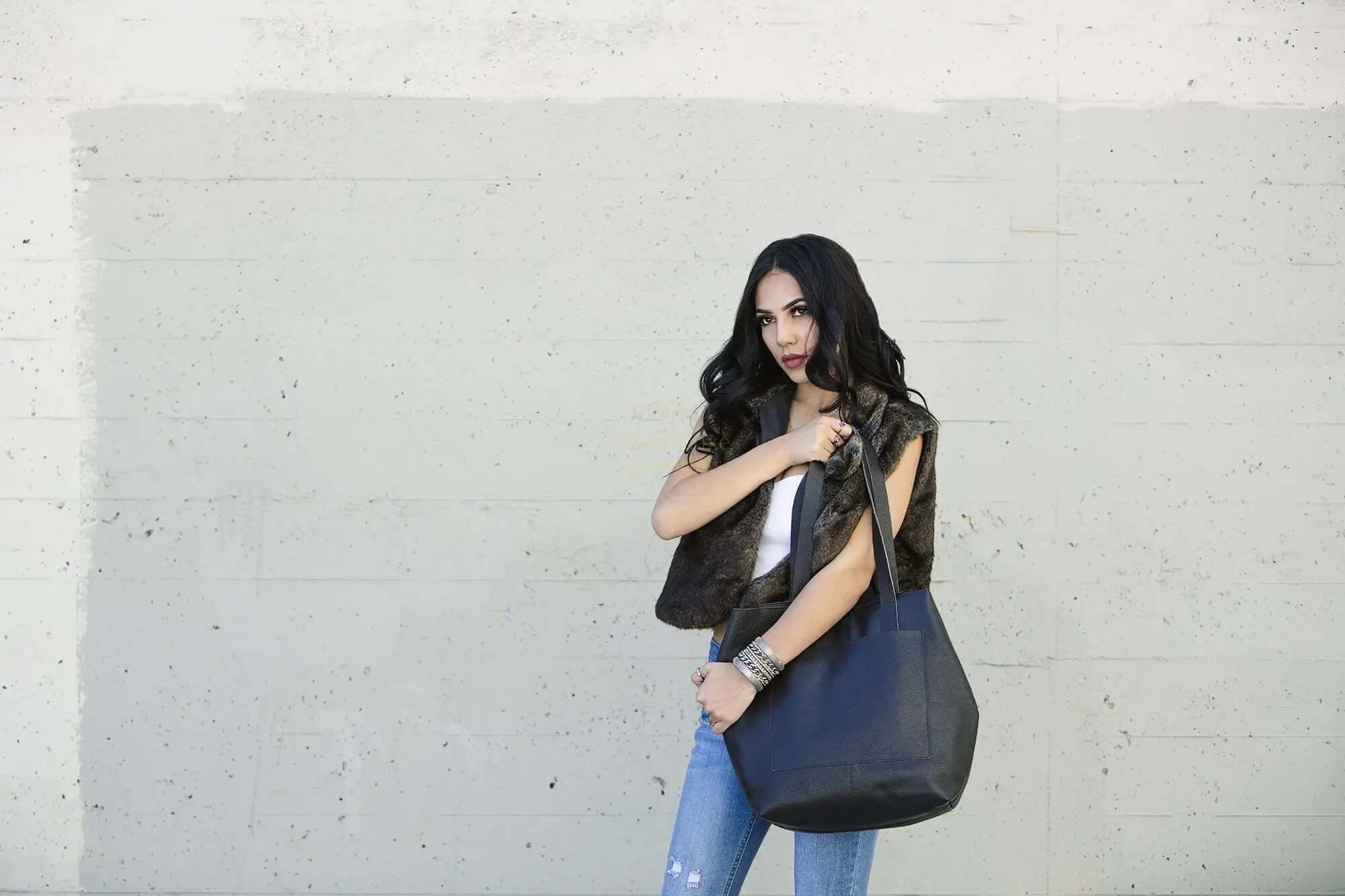 A model showcasing a professional journalist tote bag against a minimalistic backdrop, highlighting its stylish design.
