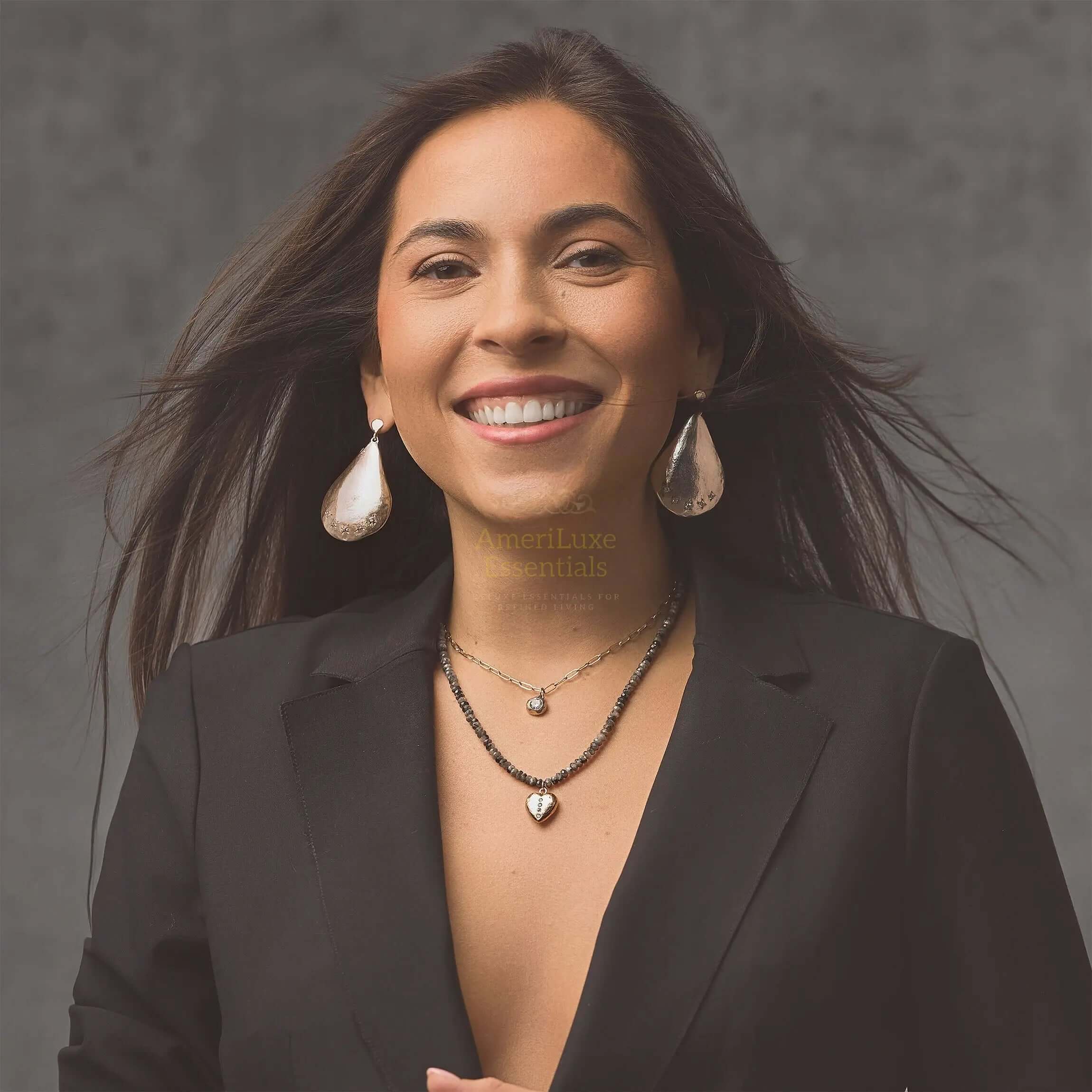 Smiling woman wearing Parisian designer earrings and necklace, showcasing elegance and style.
