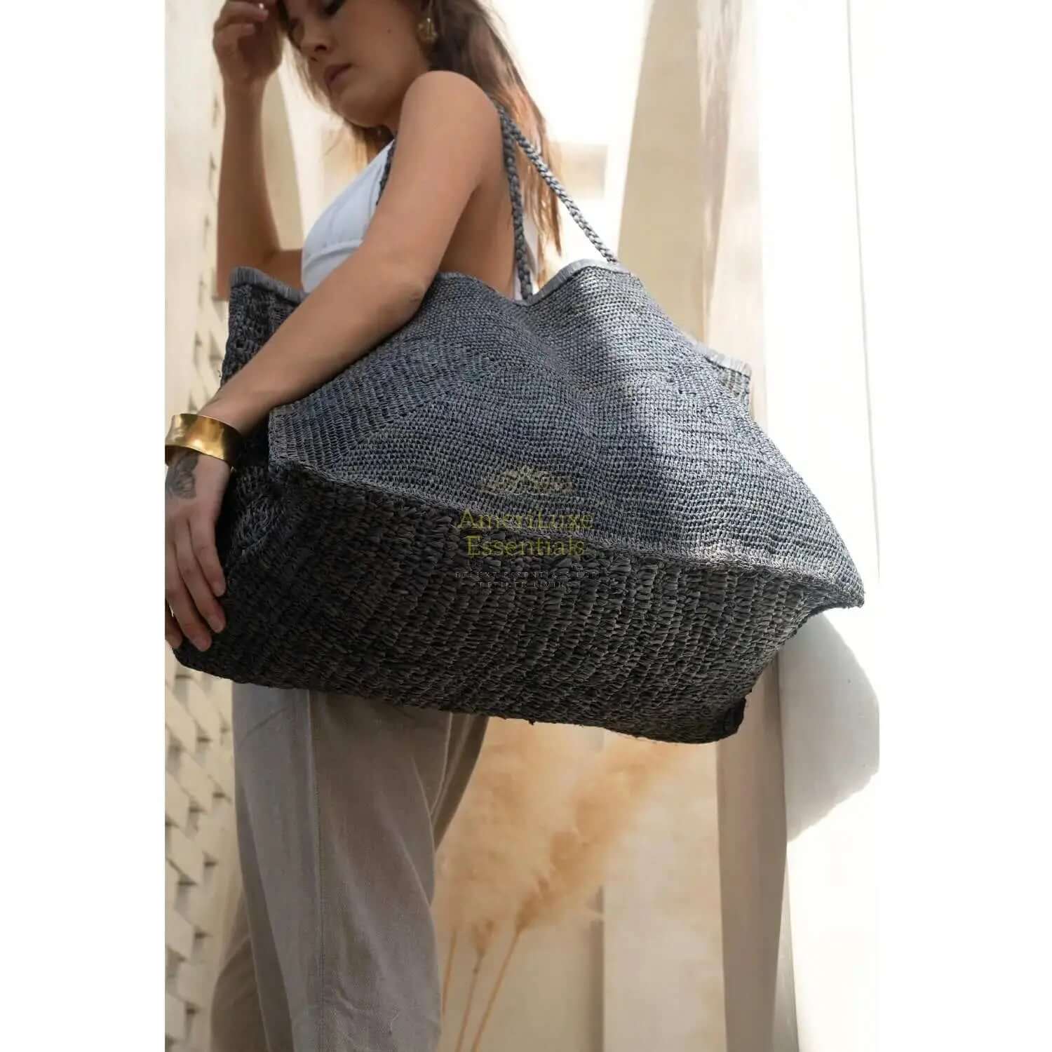 Model showcasing Clipa XXL raffia beach tote, handmade and eco-friendly, perfect for beach essentials.