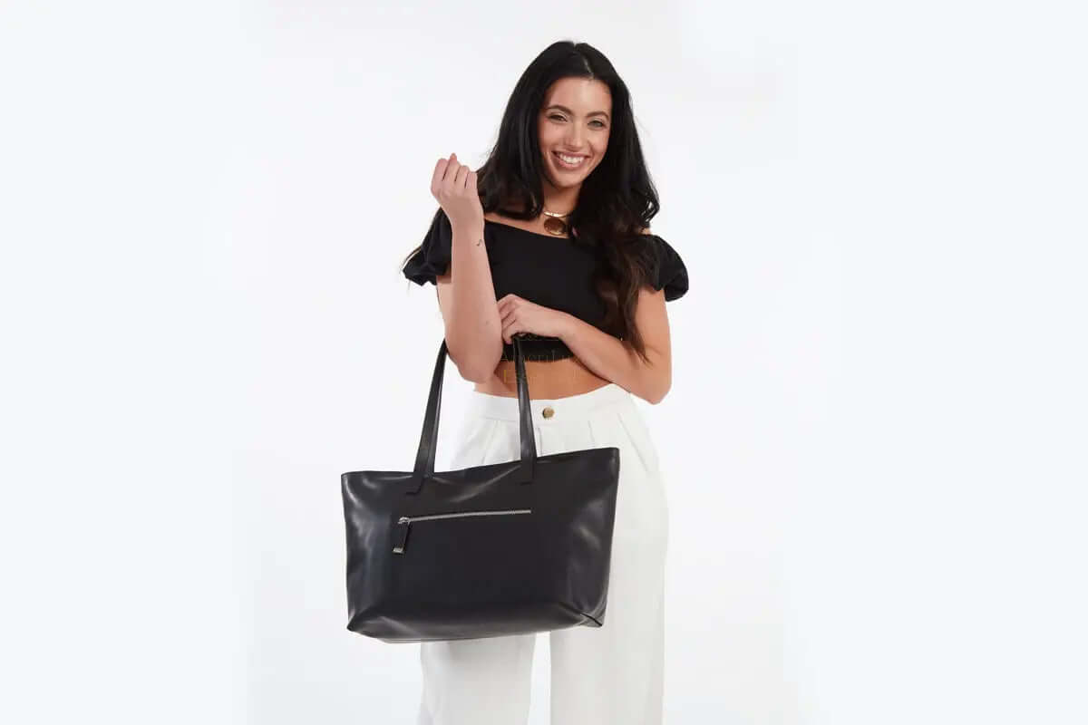 Model showcasing the Mid Zip Tote Bag in black, featuring a stylish design and practical zip closure.