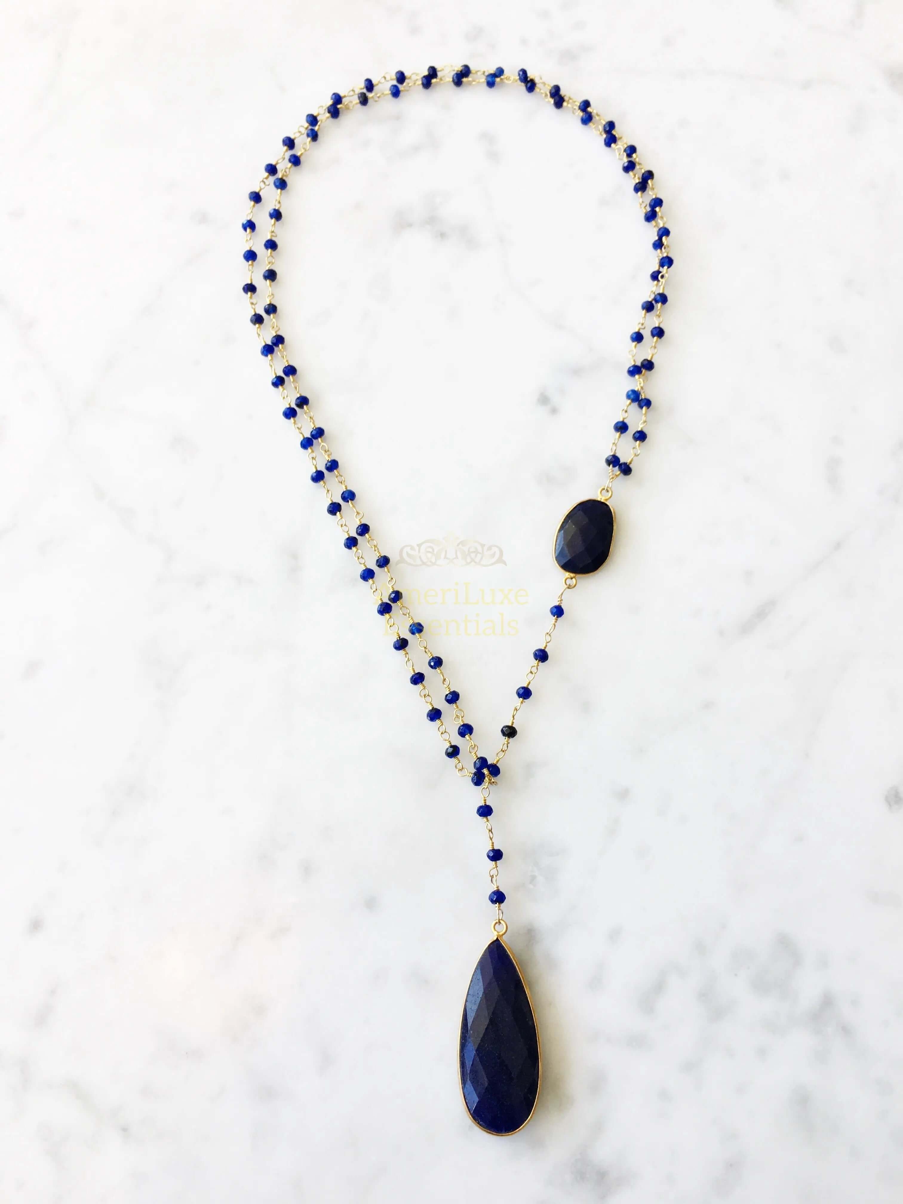 Diana Montecito sapphire necklace showcasing stunning sapphire drop against a marble background.