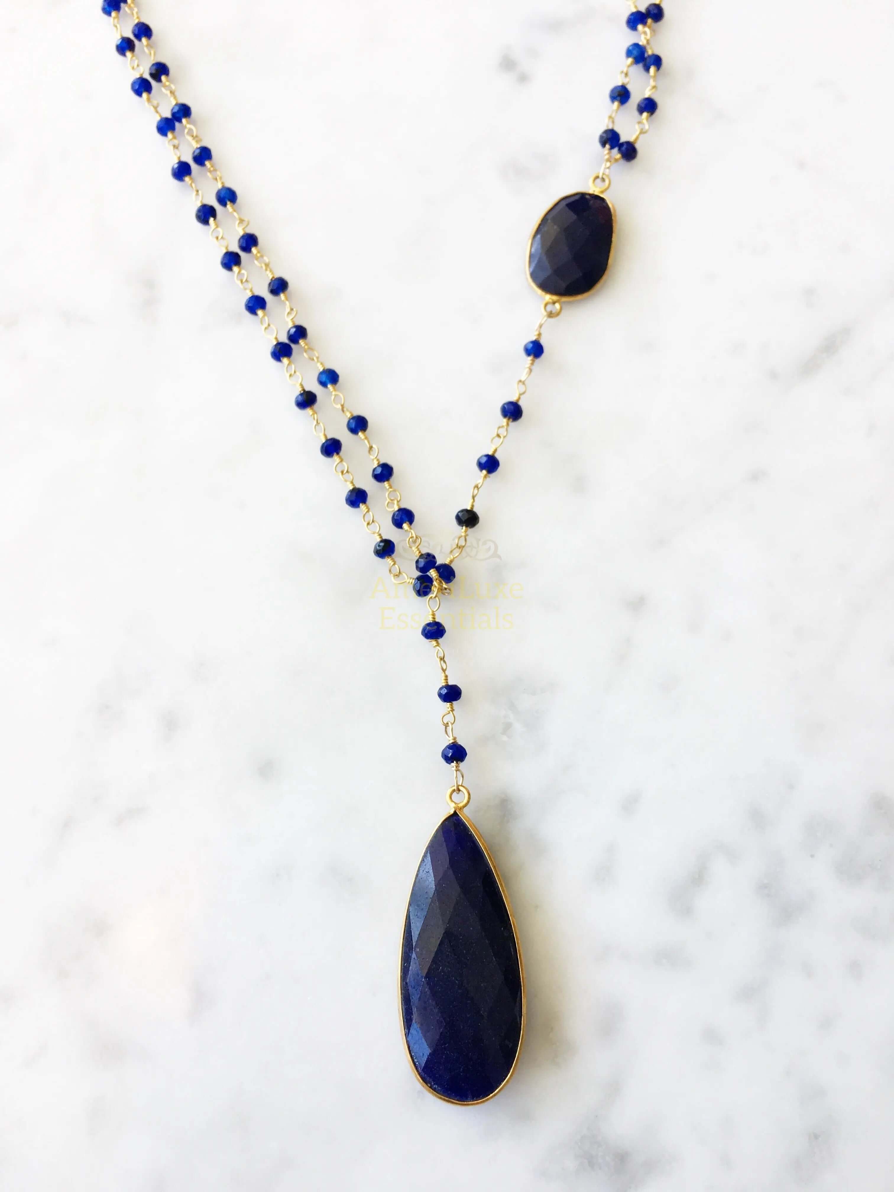 Diana Montecito sapphire necklace with sapphire drop elegantly displayed on a marble background.