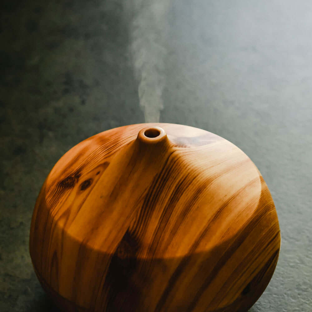 Diffuser Oil Blends - Essential and Premium Fragrance Blends in a wooden diffuser releasing fragrant mist.