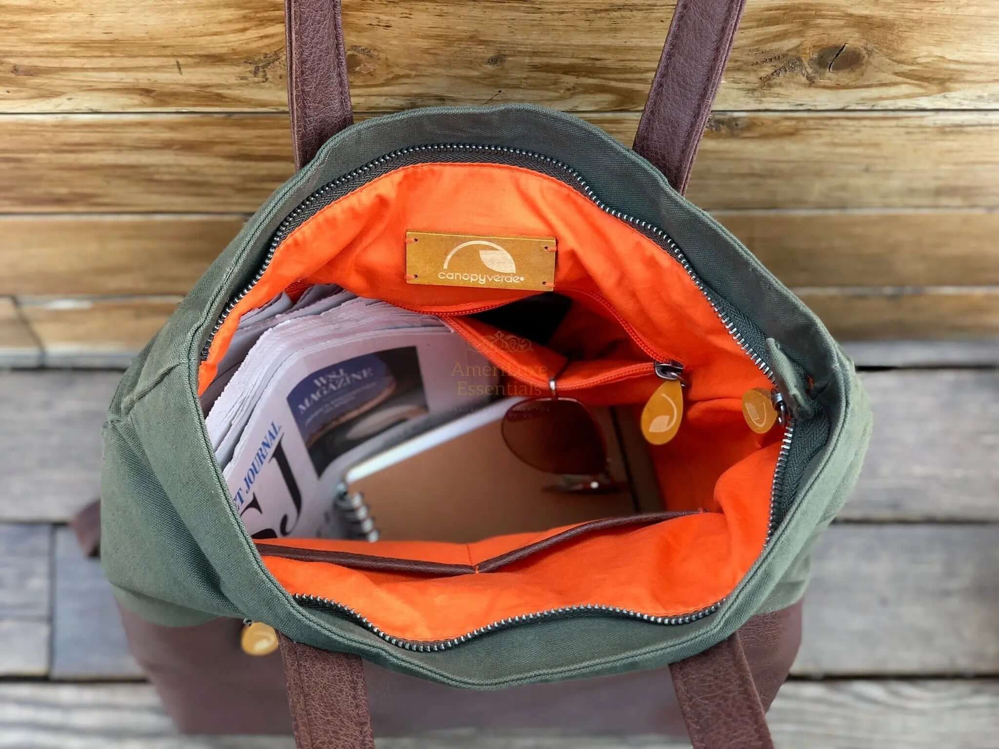 Interior view of the Greenpoint Convertible Backpack Purse showing pockets and vibrant orange lining.