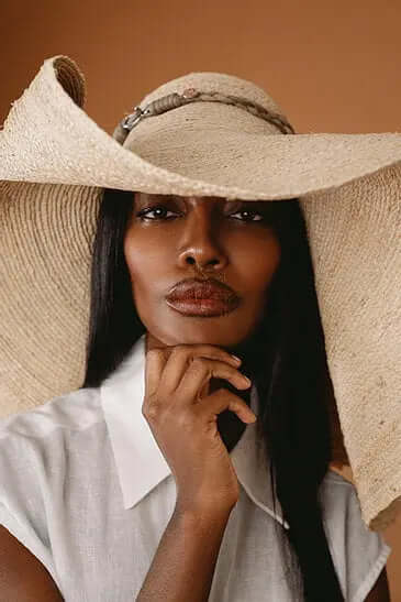 A woman wearing the Grand Belmont sun hat, showcasing its stylish design and wide brim for sun protection.